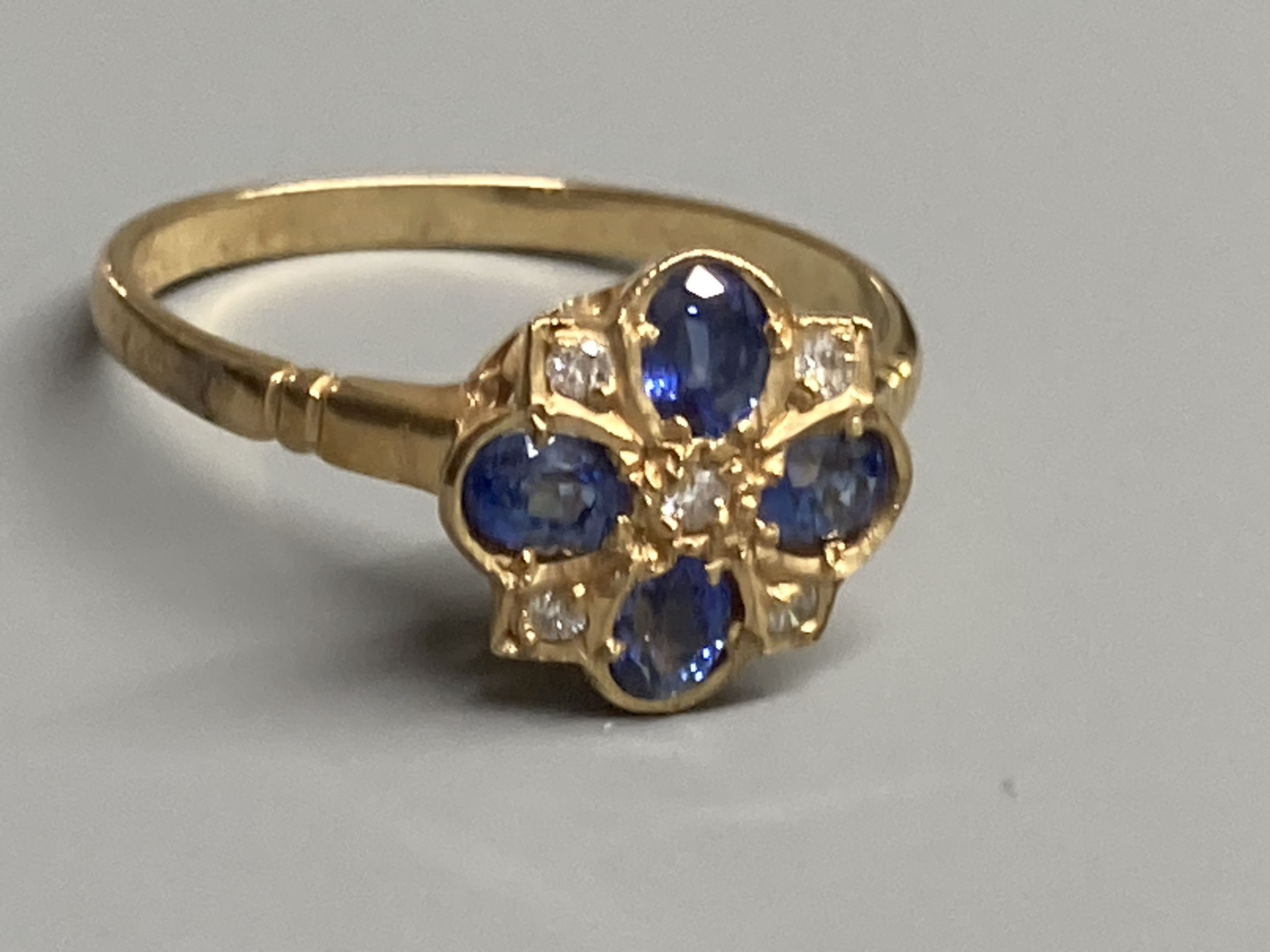 A modern 9ct gold, sapphire and diamond cluster ring, size O, gross 2.2 grams.